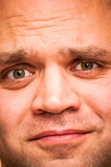 Sorrowful, sad, squinting man. Facial expression, emoji face, emotion close-up.