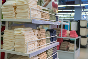 Stacks of colored towels on the shelves in supermarket