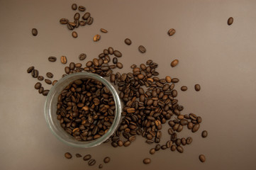 glass jar with coffee and coffee beans scattered on the table