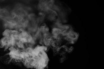 White smoke on a black background. Texture of smoke. Clubs of white smoke on a dark background for an overlay