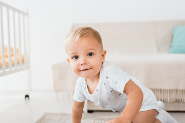 Fototapeta premium adorable toddler looking at camera on white room background