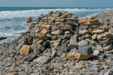 Wall of stones on the sea shore beach.