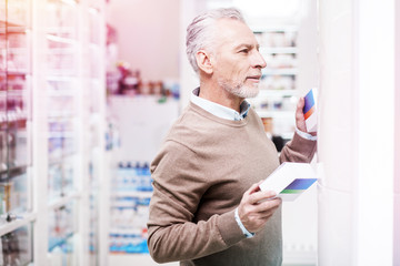 Doubting customer deciding between two boxes in a pharmacy