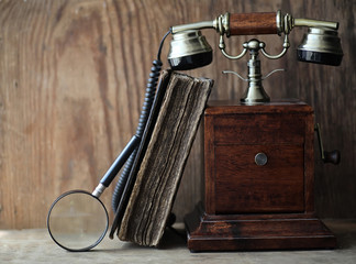 Old telephone and retro book on a wood