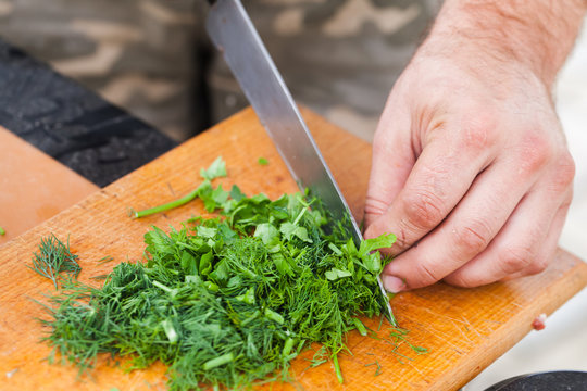 Greens chopping. Cook hands with knife