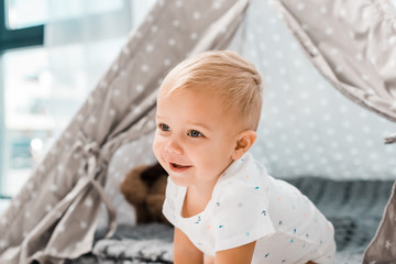 smiling adorable toddler with baby wigwam on background © LIGHTFIELD STUDIOS