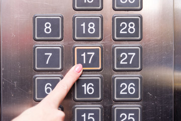 Fototapeta na wymiar Elevator buttons with finger pushing 17 floor