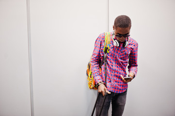 African american man in checkered shirt, sunglasses and jeans with suitcase and backpack. Black man...