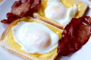 Poached eggs on white toast with bacon