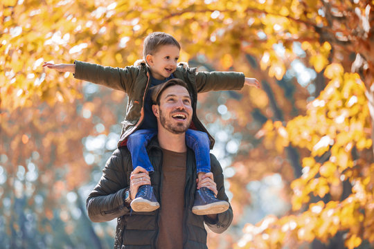 Happy father and son having fun in autumn park