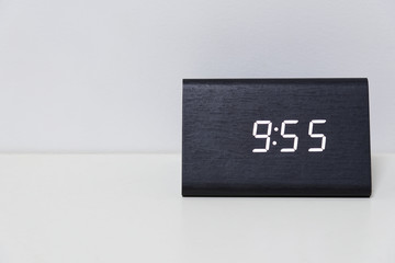 Black digital clock on a white background showing time 9:55