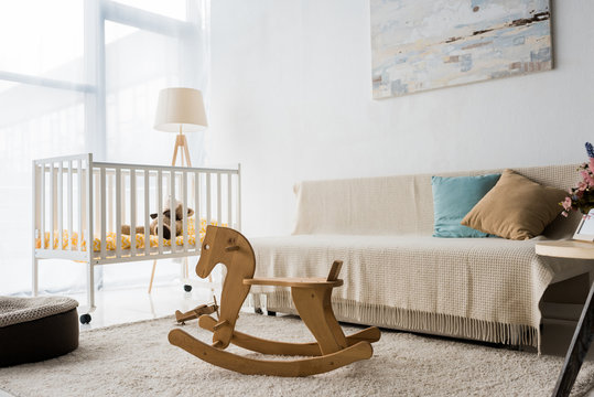 Modern Interior Design Of Nursery Room With Crib And Rocking Horse Chair