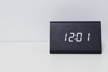 Black digital clock on a white background showing time 12:01