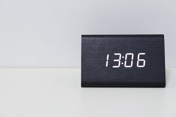 Black digital clock on a white background showing time 13:06  