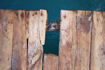 the rotten boards of the pier over the sea
