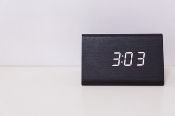 Black digital clock on a white background showing time 3:03