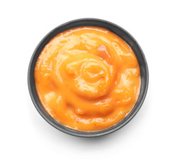 Tasty orange sauce in bowl on white background