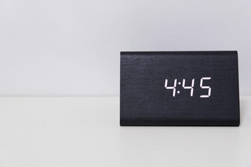 Black digital clock on a white background showing time 4:45