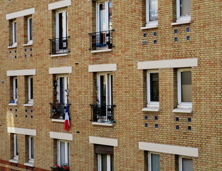 Façade de briques jaunes avec drapeau bleu blanc rouge