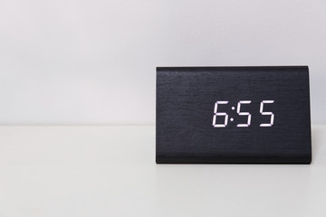 Black digital clock on a white background showing time 6:55