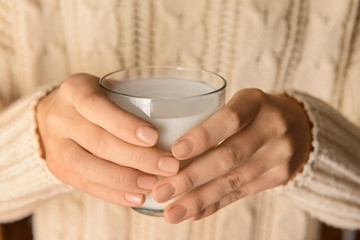 Woman holding glass of delicious milk, closeup