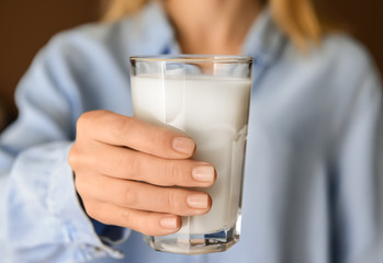 Woman holding glass of delicious milk, closeup