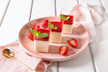 Glasses with tasty strawberry panna cotta on plate