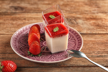 Glasses with tasty strawberry panna cotta on plate