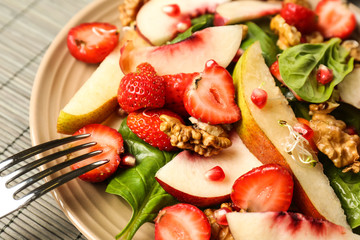 Delicious fresh salad with walnuts on plate, closeup