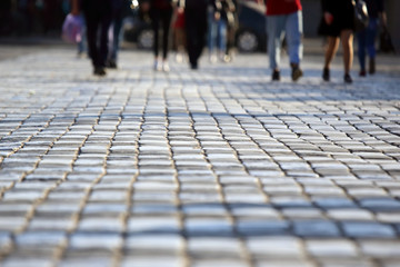 Fototapeta premium people cross the road at a pedestrian crossing on the pavement in a blurred focus