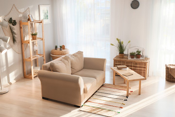 Living room interior in eco style with comfortable sofa and green plants