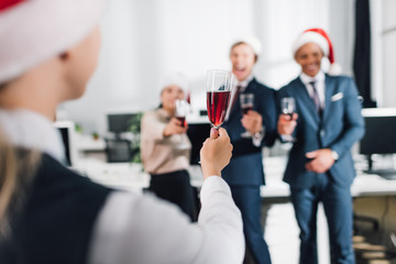 selective focus of young coworkers drinking wine and celebrating new year in office