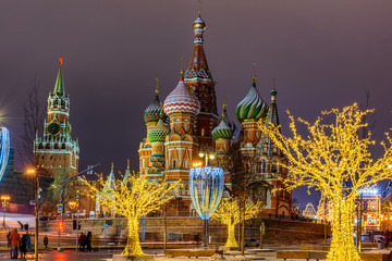 Fototapeta premium Night view of Spasskaya Tower, Moscow Kremlin and Saint Basil s Cathedral in Moscow, Russia. Architecture and landmarks of Moscow. Moscow with Christmas decoration.