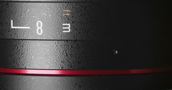 Rotating cinema camera modern lens. Close up shot. Low key.