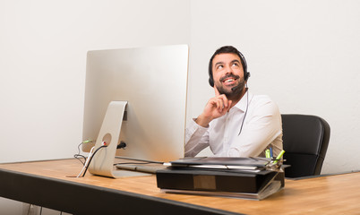 Telemarketer man in a office thinking an idea while looking up