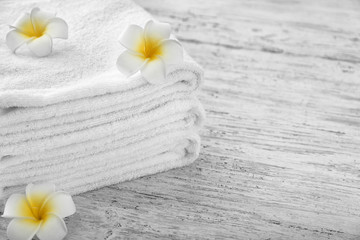 Towels with flowers on wooden background