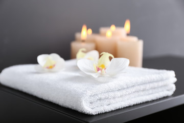 Fototapeta na wymiar Bath towels with flowers on dark table