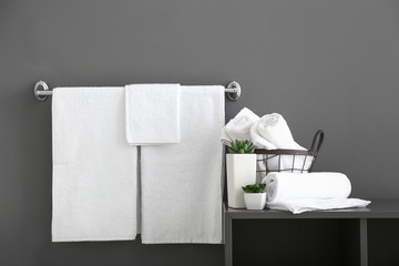 White bath towels near grey wall - obrazy, fototapety, plakaty