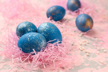 Nest with Easter eggs on color background