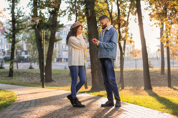 Young man proposing to his beloved in autumn park