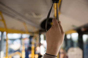 Girl holding on a handle on the bus