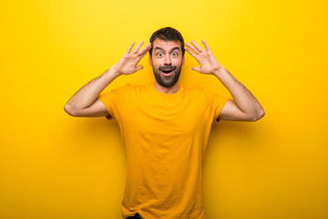 Fototapeta na wymiar Man on isolated vibrant yellow color with surprise and shocked facial expression