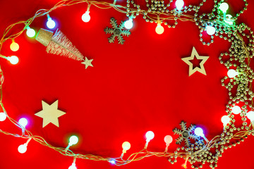 Christmas lights on red background, top view