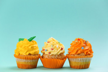 Tasty cupcakes on color background