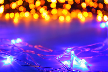 Glowing Christmas lights on table, closeup
