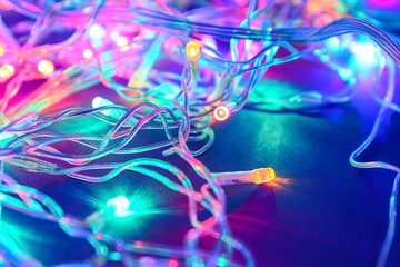 Glowing Christmas lights on dark background, closeup