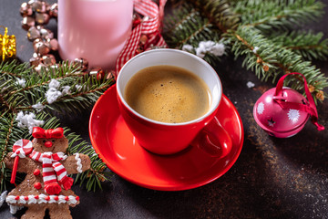 Coffee espresso, red cup of coffee and Christmas decorations on dark background.