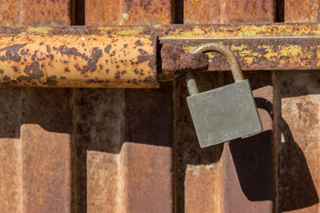 padlock closing rusty metal door, old rusty iron door with closed locks, close up padlock on the door for metal door lock 