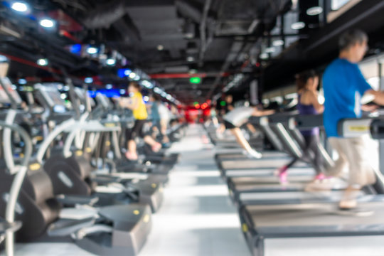 Blurred of fitness gym center interior background with two rows of cardio machine
