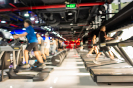 Blurred of fitness gym center interior background with two rows of cardio machine